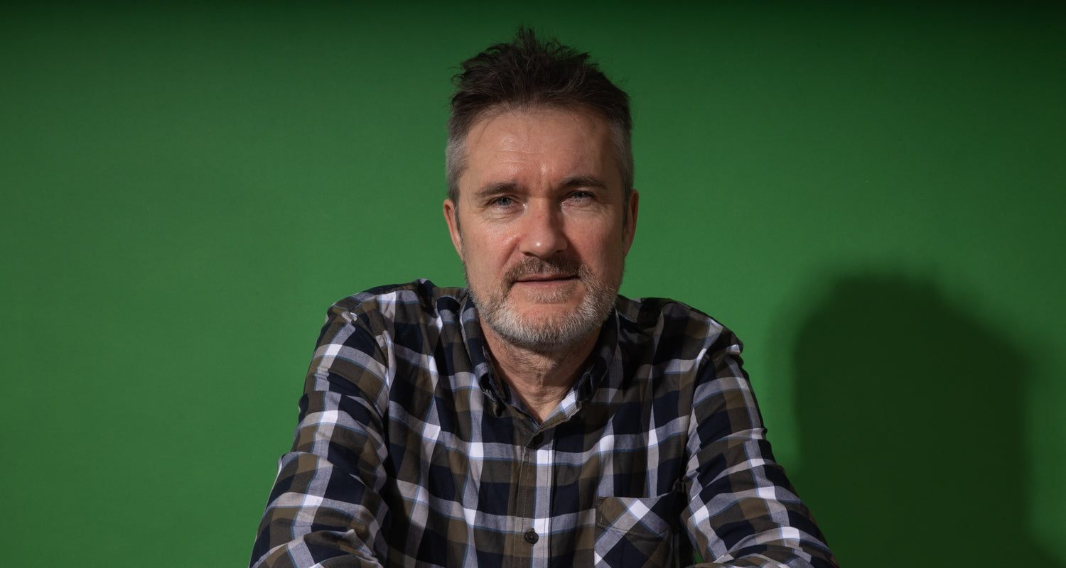 Man wearing a plaid shirt against a green screen background